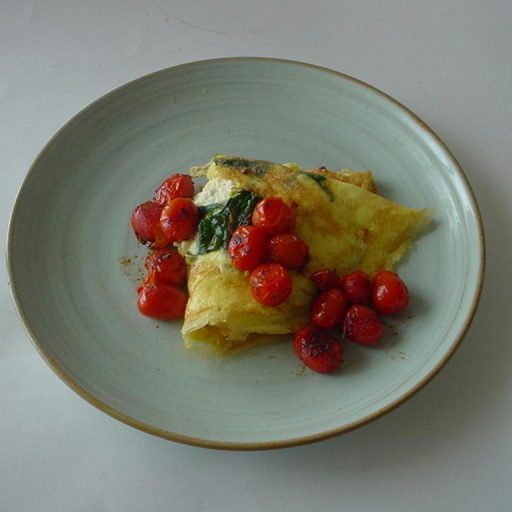 Tortilla Con Espinacas Y Queso Feta, Bañada Con Salsa Caliente De Hierbas Y Tomates