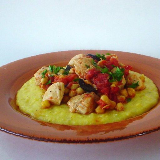 Pollo Morella Con Garbanzos, Tomates Y Aceitunas, Servido Sobre Polenta